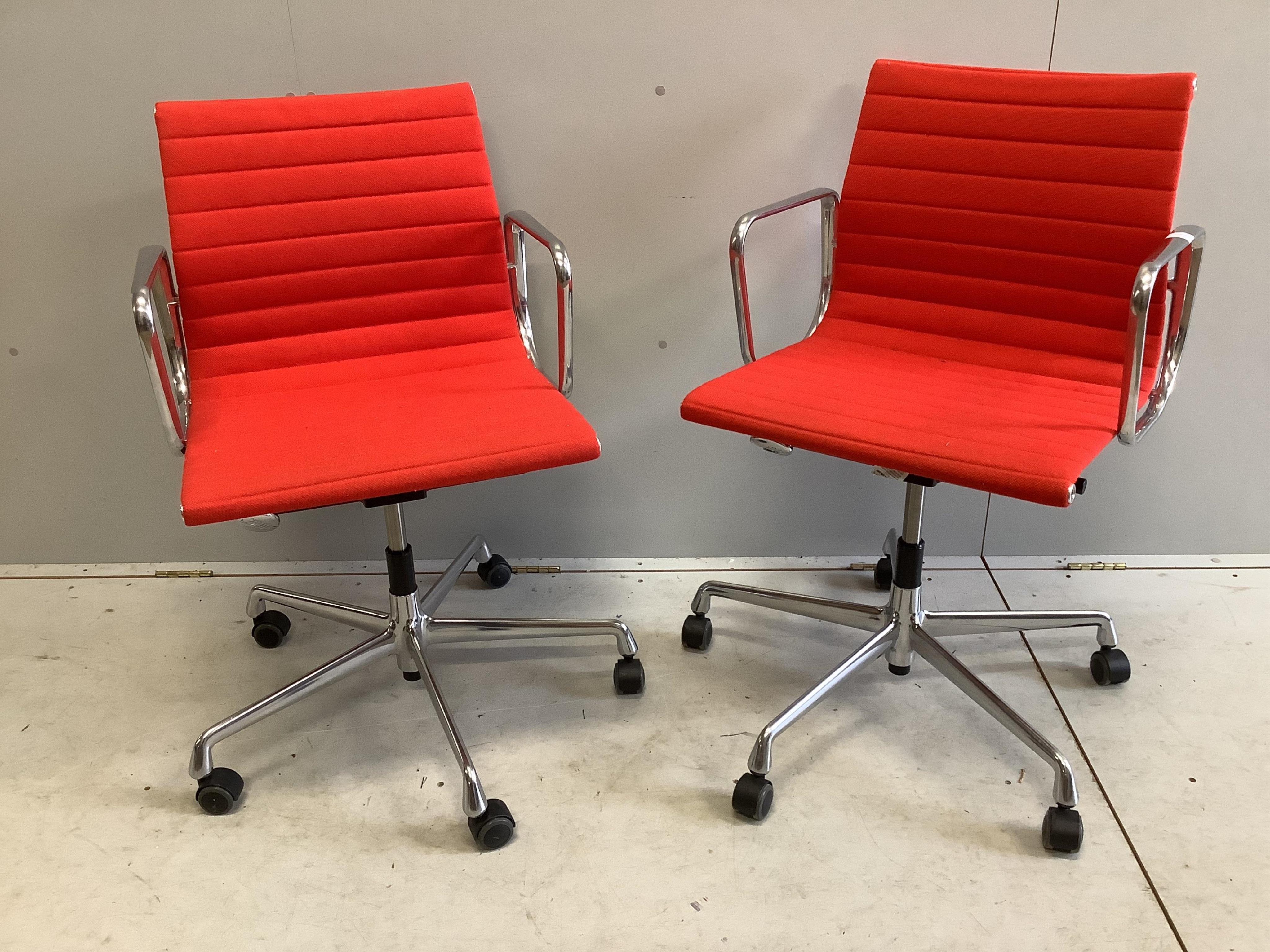 A pair of Vitra Eames EA117 red fabric office chairs, width 57cm, depth 52cm, height 83cm. Condition - fair to good